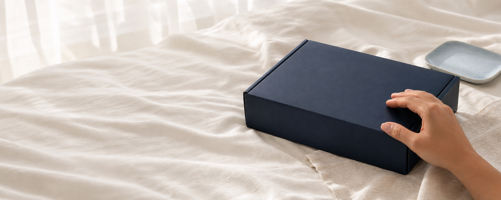 Discreet INTIMYX packaging on soft ivory bedding